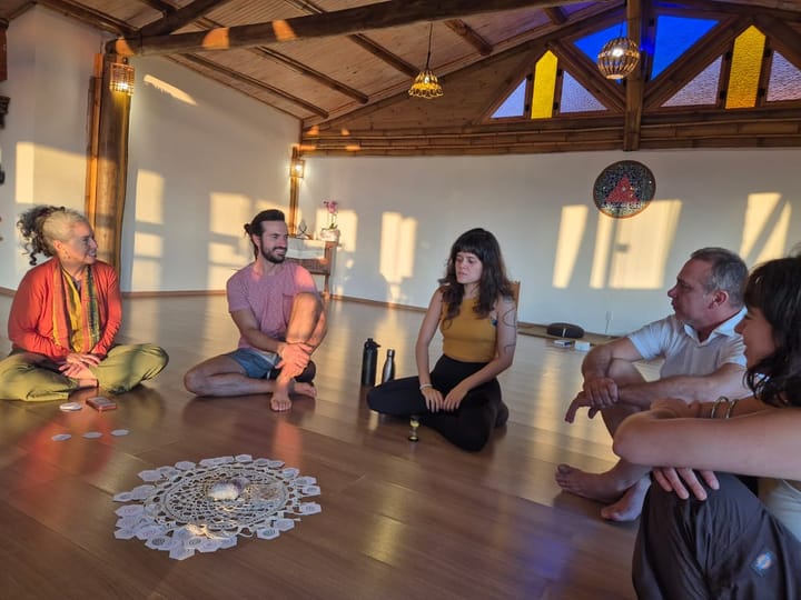 A photo of people sitting on wooden floor playing the Cultural Transformation game around the cards
